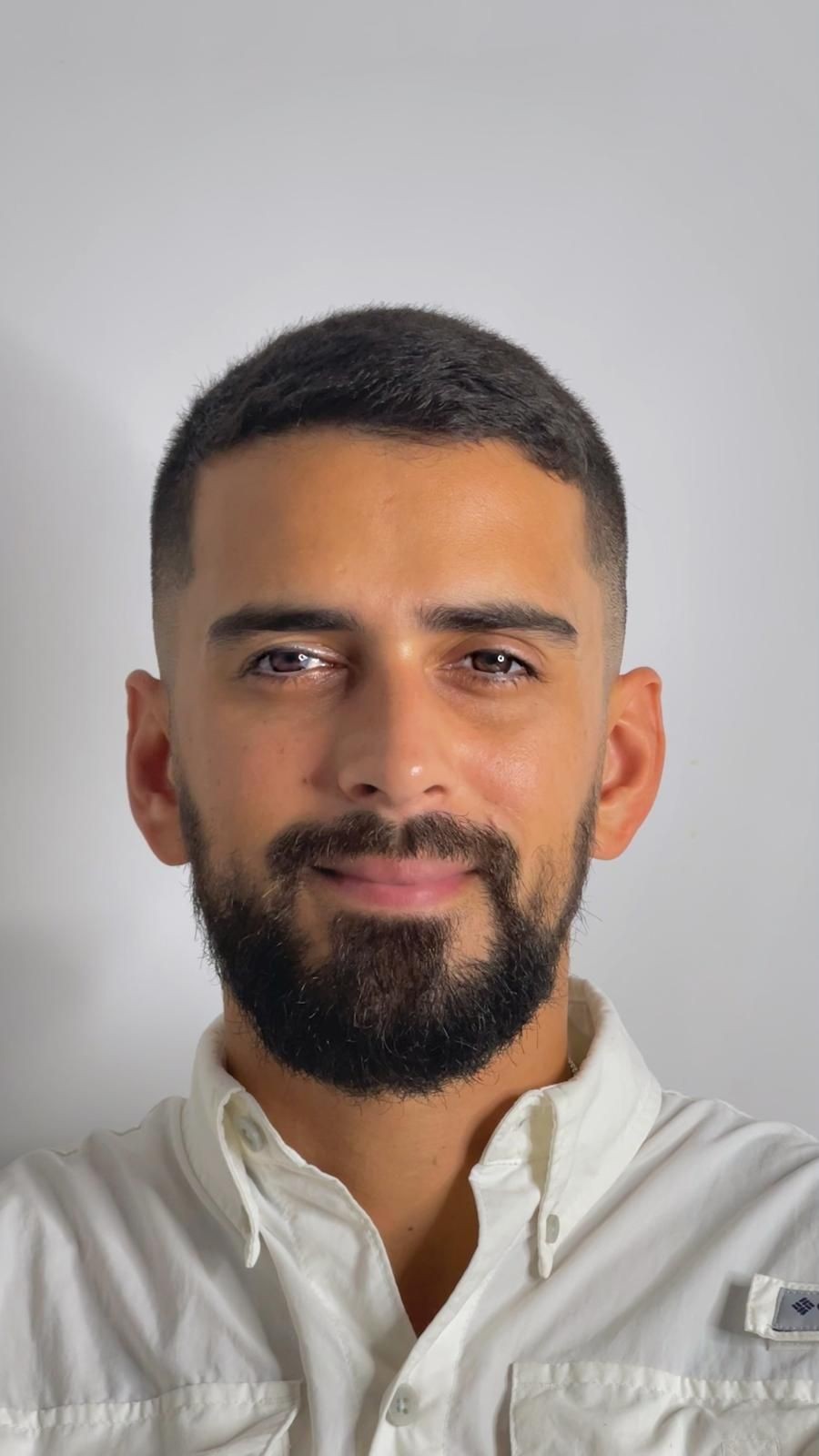 Person wearing a white button-up shirt, standing against a plain white background.