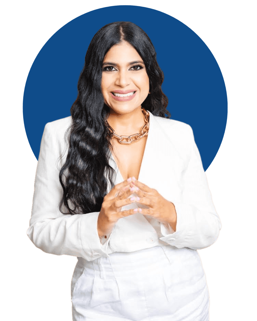 Person wearing a white suit with long wavy black hair, posing against a blue circle background.